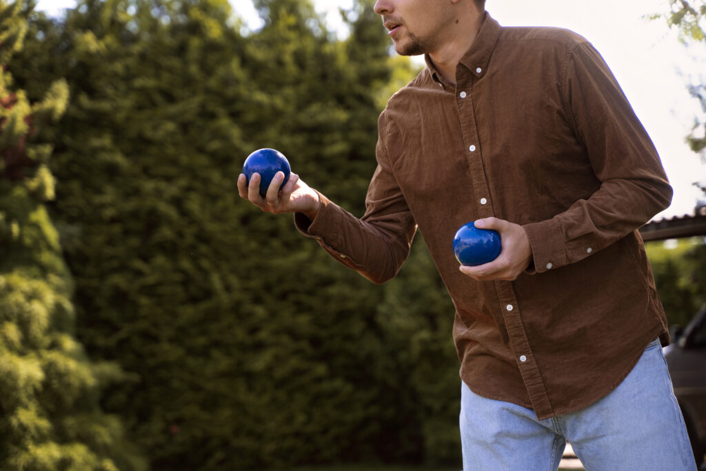 Attività sportive - side view man holding metallic balls